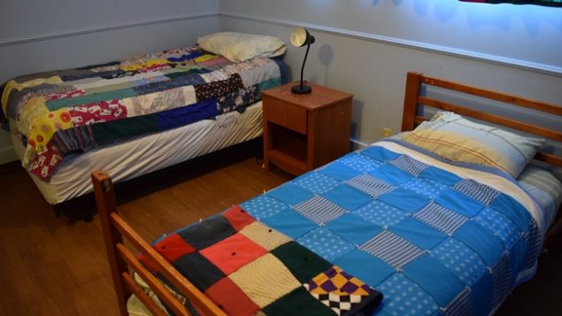 Two beds made up with pretty patchwork quilts in Austin's Place Women's Shelter
