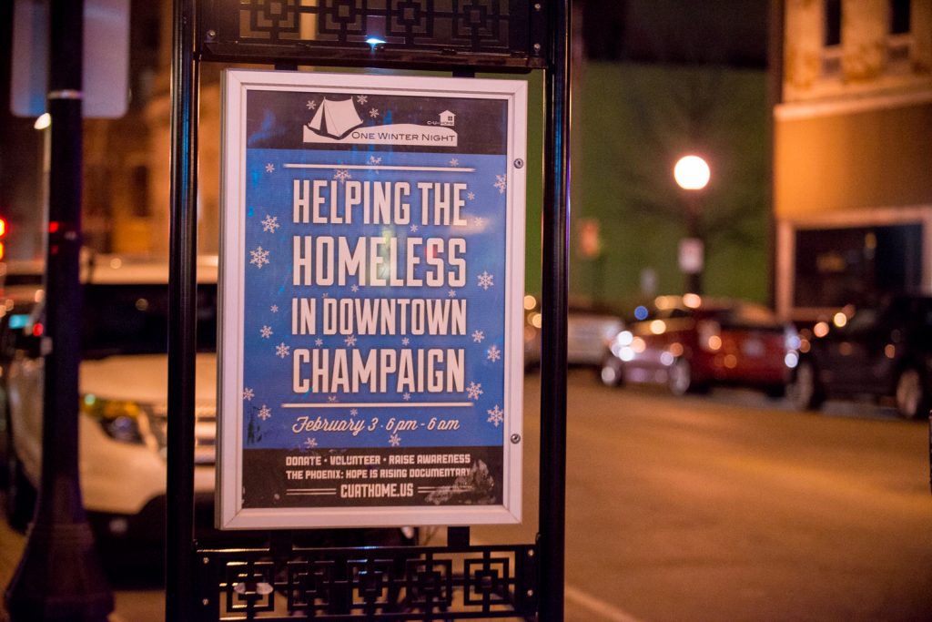 A One Winter Night sign that reads, "Helping the Homeless in Downtown Champaign"